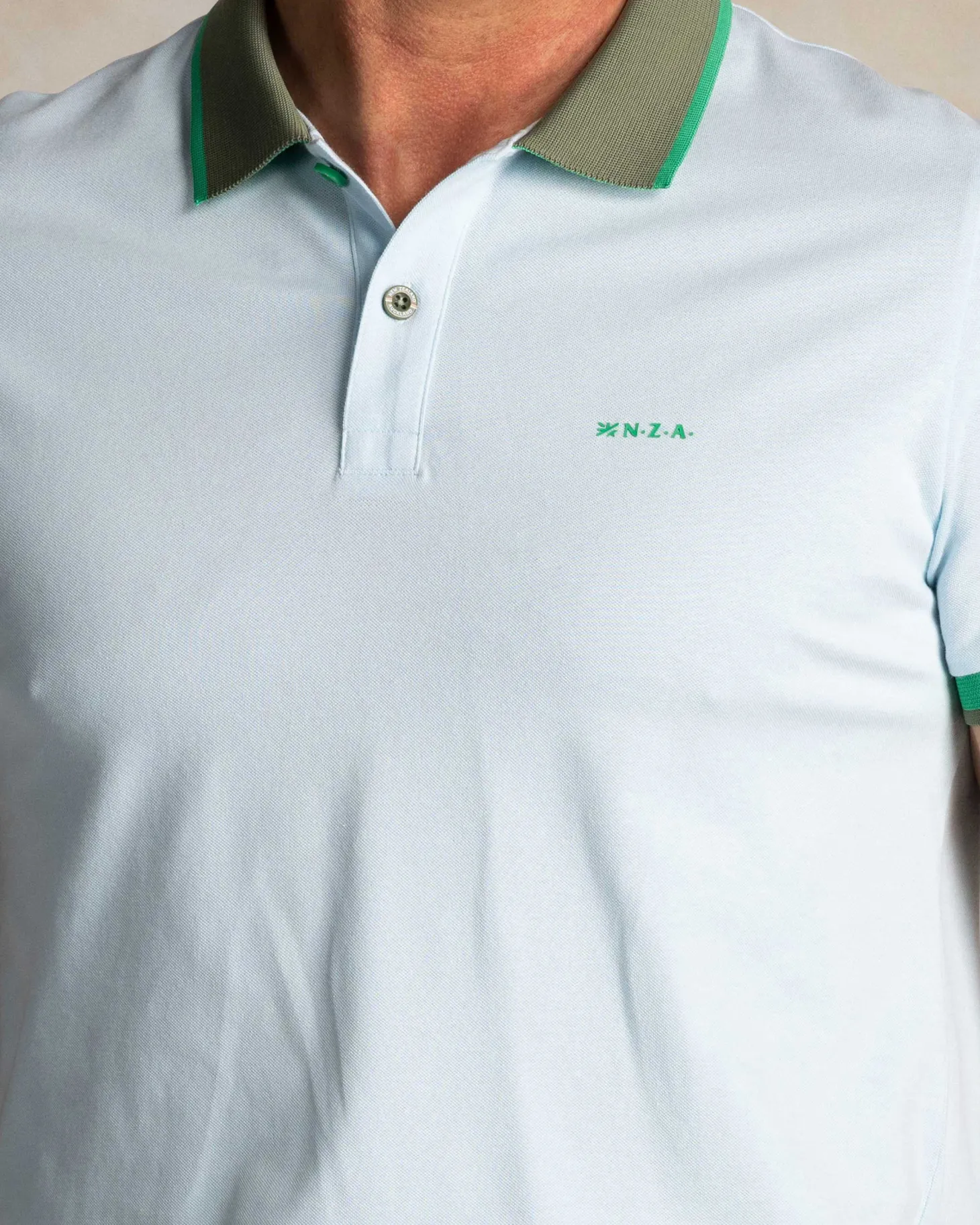 Hellblaues Baumwoll-Poloshirt mit grünem Kragen