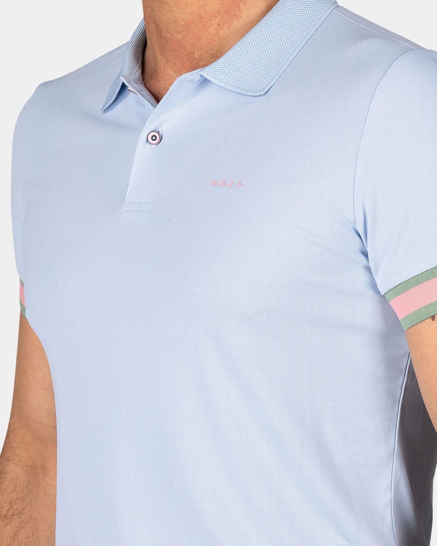 Pastellblaue Polo mit orangefarbenen Details